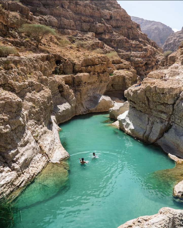 Muscat: Wadi Shab & Bimmah Sinkhole Tour with Pickup & Lunch - Swimming toward the waterfall and cave