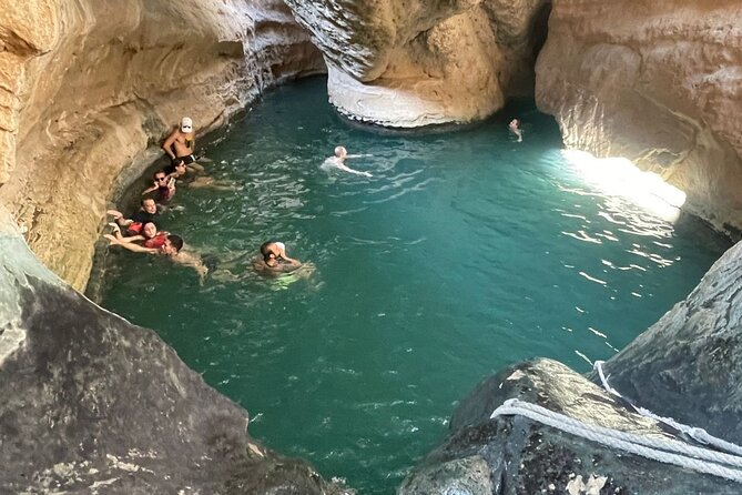 Swimmers in the flooded canyon at Wadi Shab, eastern Oman